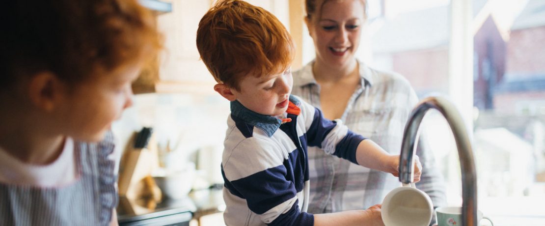 A family washing up at the sink together