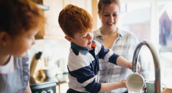 A family washing up at the sink together