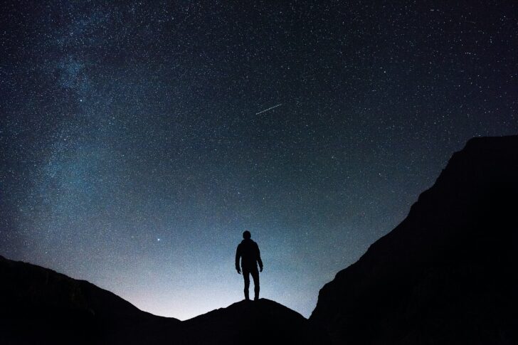 Man silhouetted against the night sky with stars
